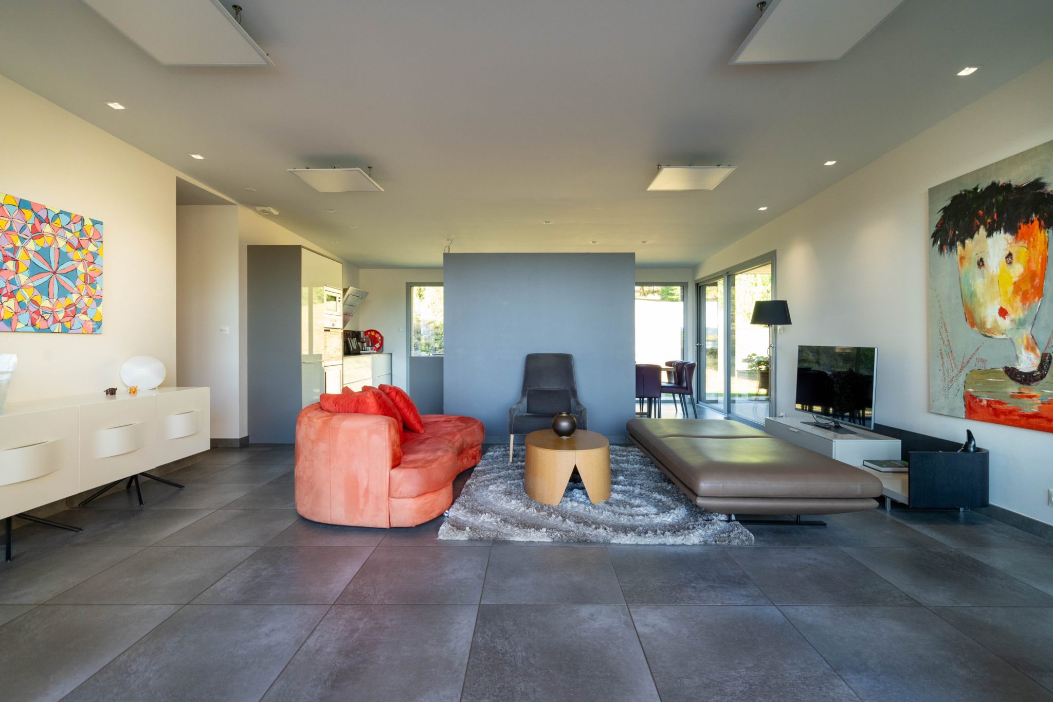 Salon moderne des Villas de Labro décoré avec des peintures aveyronnaises cascade du Déroc sur le Plateau de l’Aubrac vue de drone